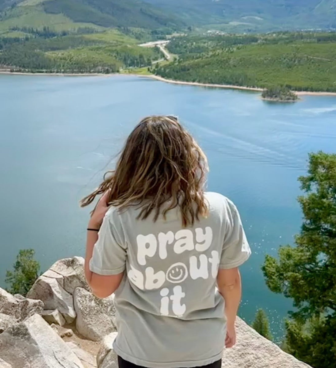 Pray About It tee above a mountain lake