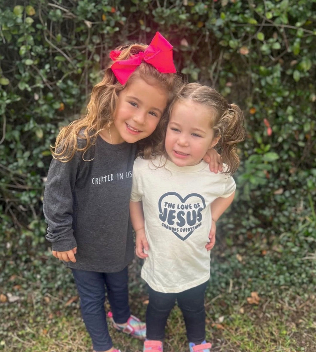 Two girls in Created In His Image and The Love Of Jesus tees