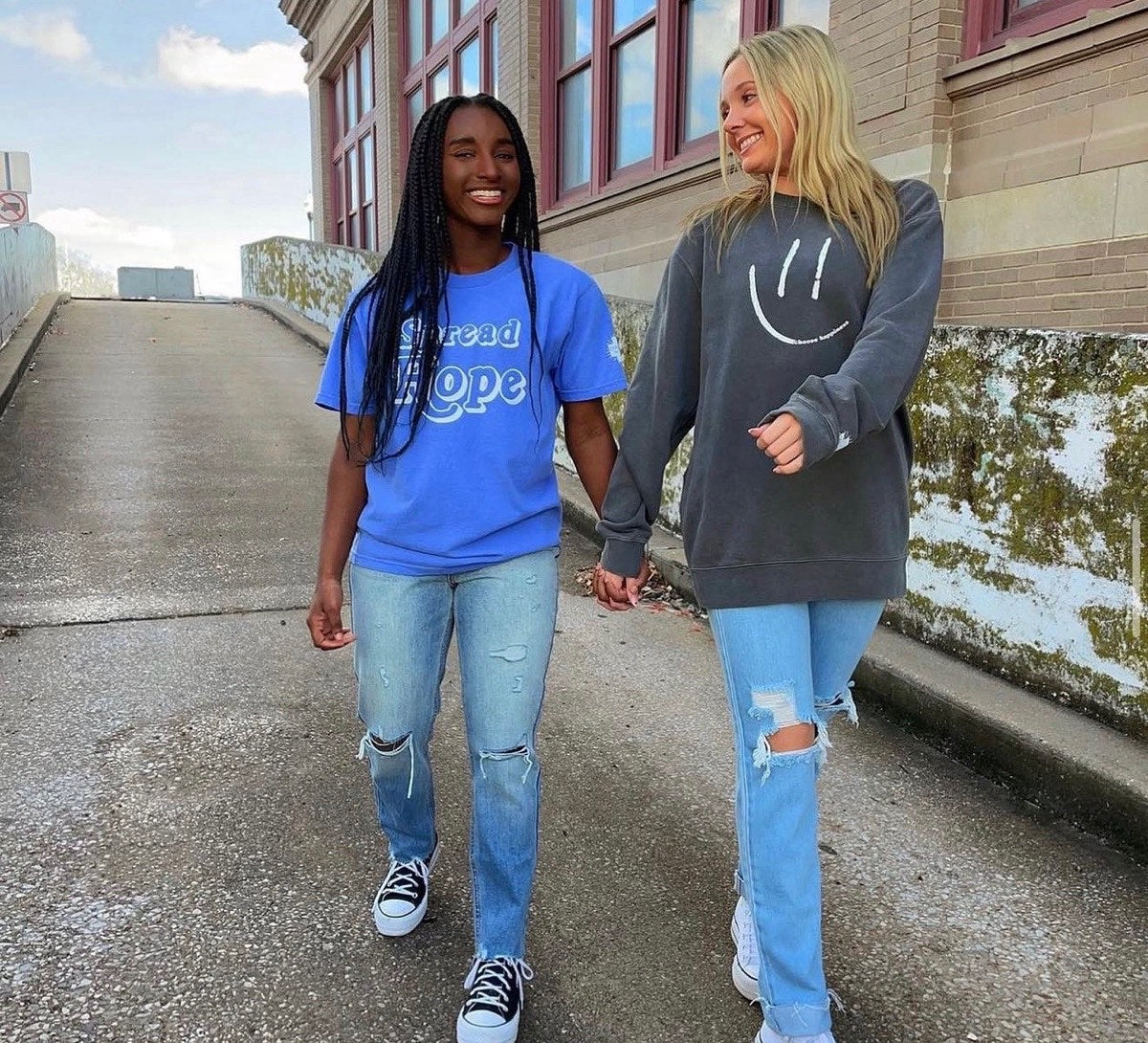 Two friends in a Spread Hope tee and a smiley crewneck